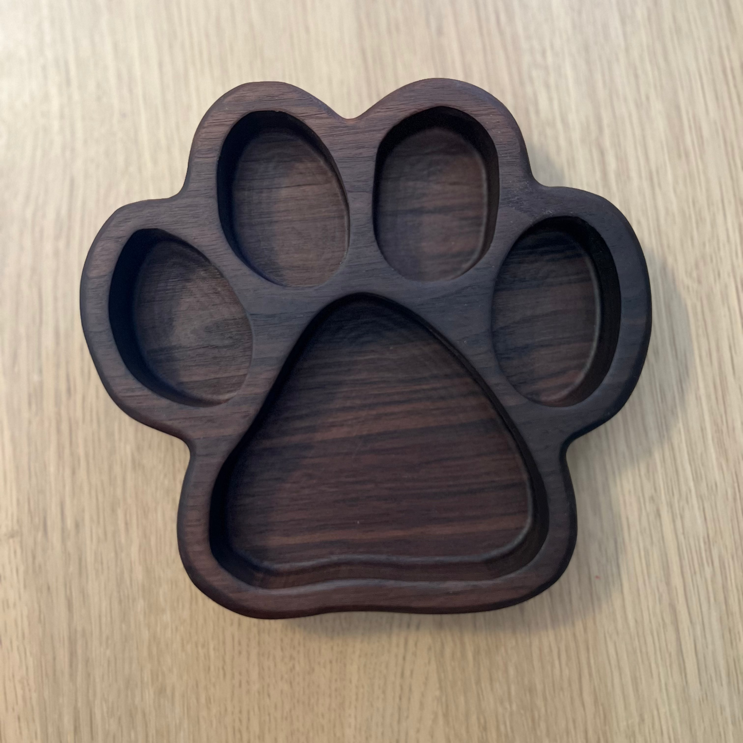 Wooden paw-shaped tray on a wooden surface