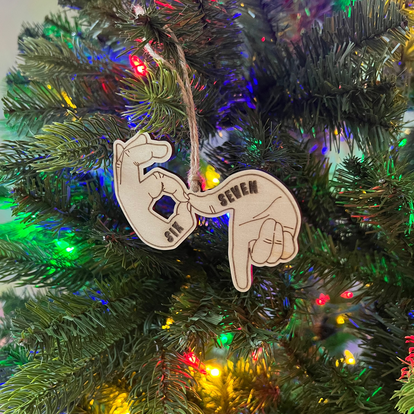 Decorative ornament shaped like a hand with raised index finger on a Christmas tree.