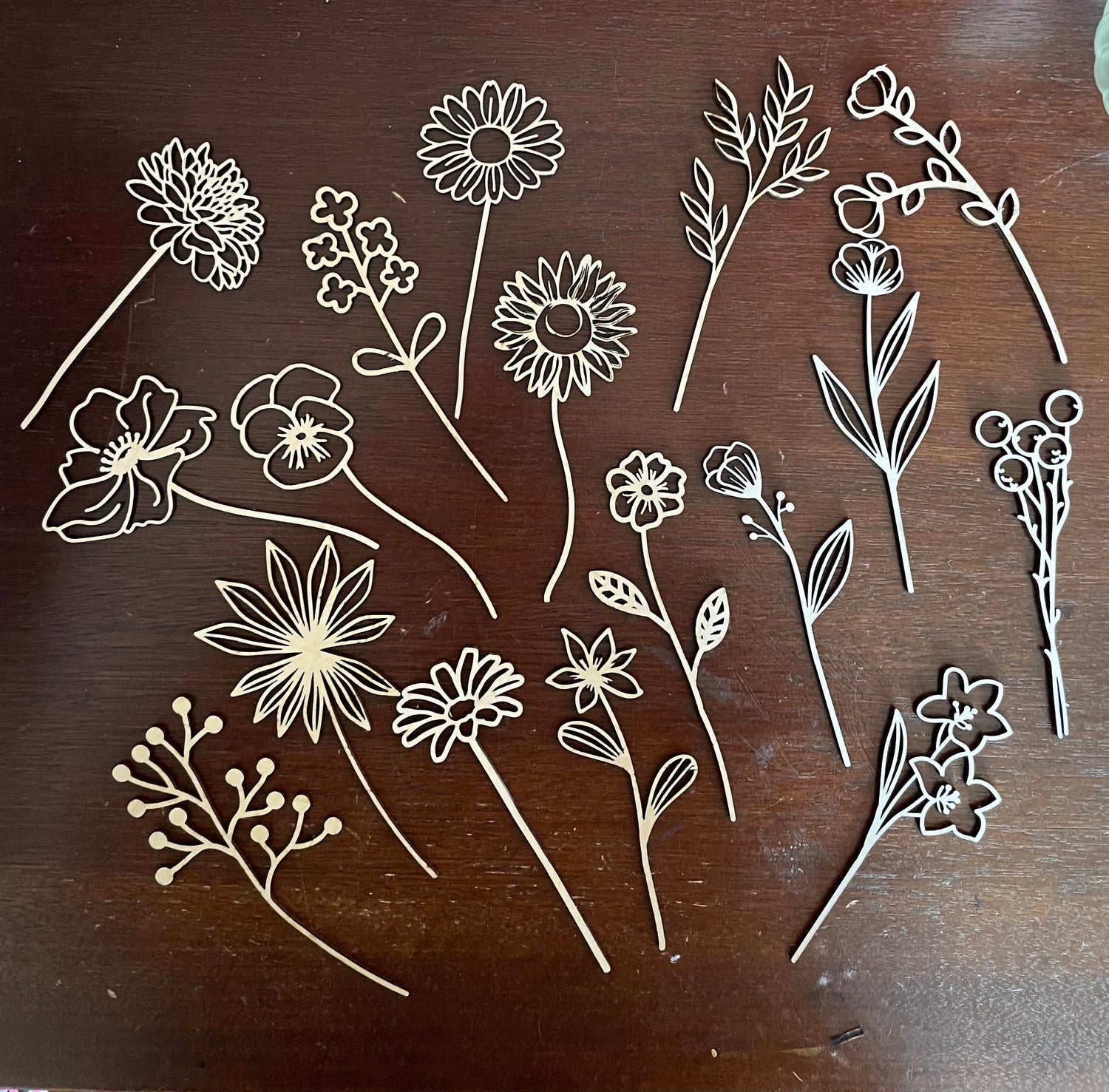 Handmade laser-cut wooden wildflowers on a wooden surface