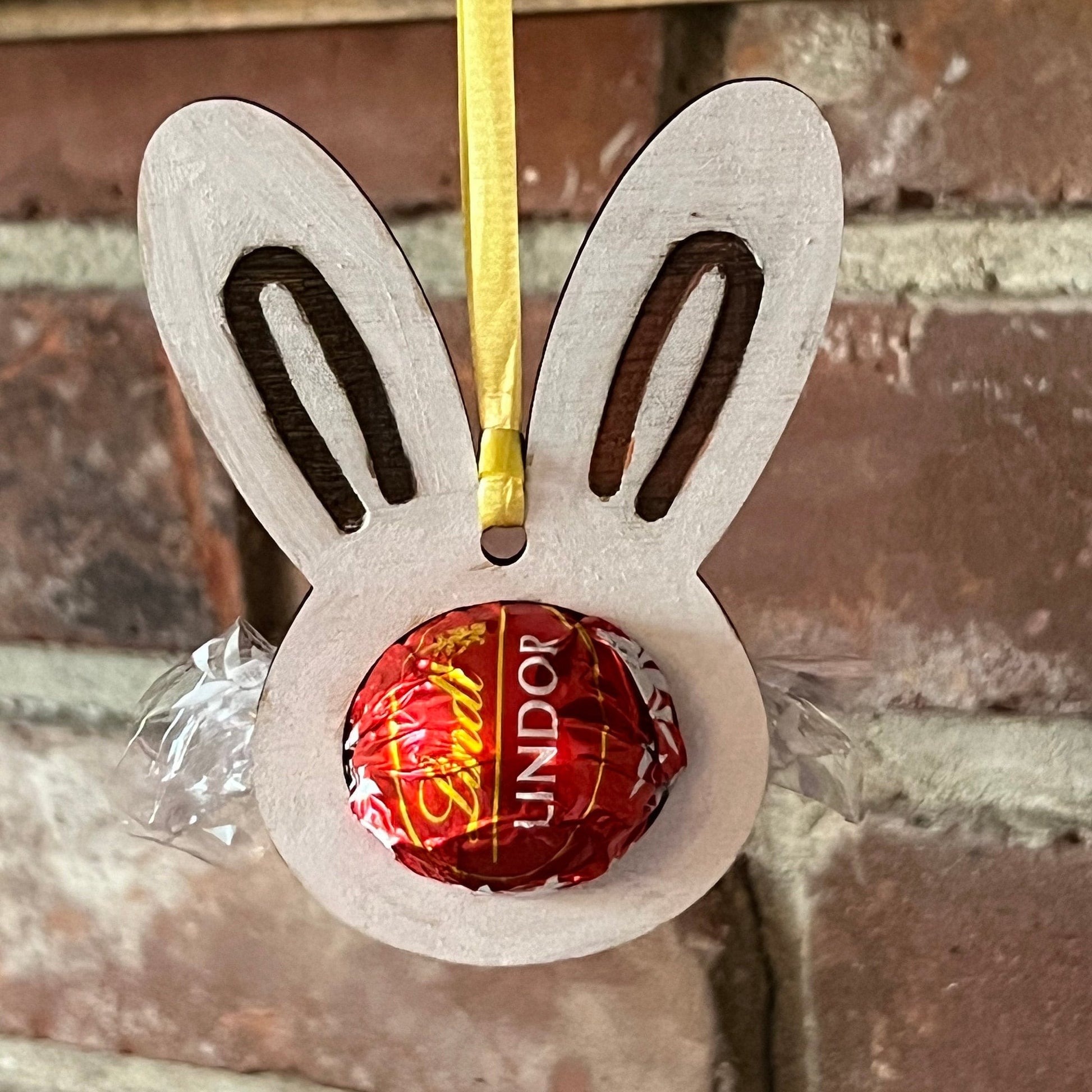 The Wet Nose Woodworks Digital Easter Lindt Holder Ornament features bunny and egg designs—SVG, PNG, PDF files for laser cutting—perfect DIY inspiration for crafters making Easter ornaments with Lindt chocolates.