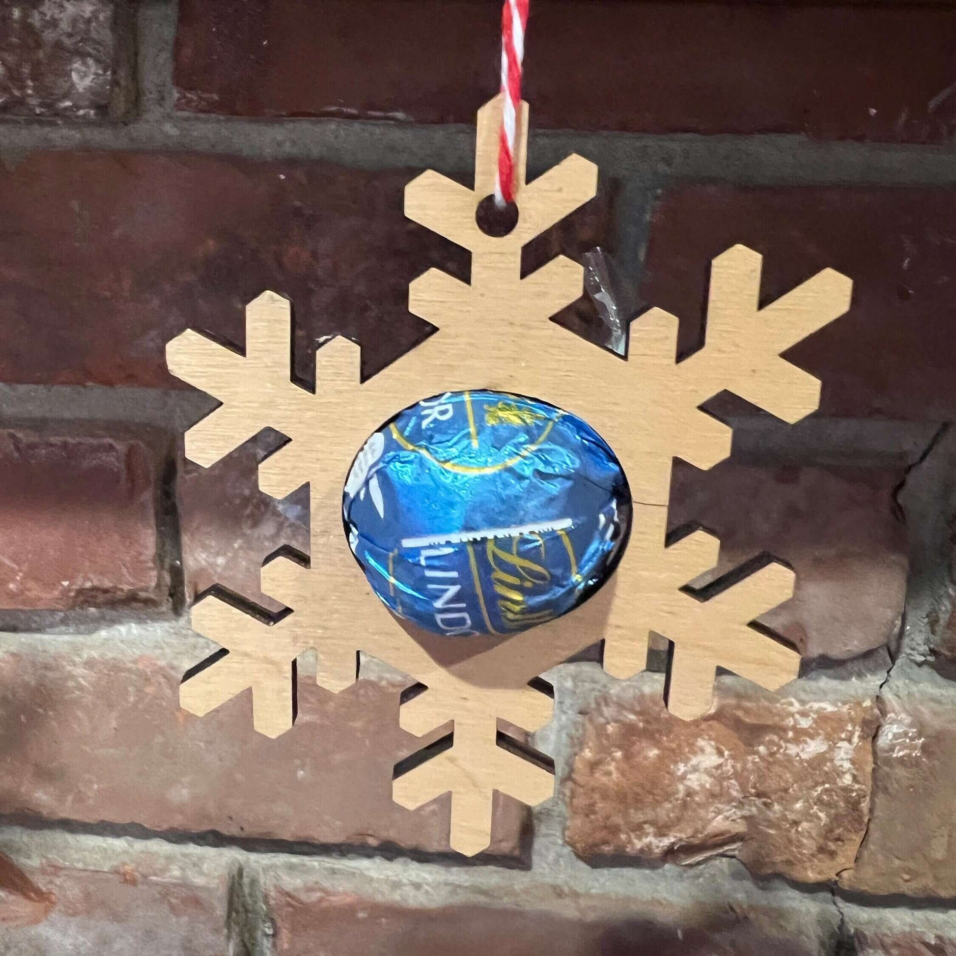 The Wet Nose Woodworks Digital Ornament Templates include a reindeer Lindt Lindor chocolate holder—perfect for festive designs. This laser-ready SVG/Lightburn file set features gingerbread man, snowflake, and reindeer ornaments.