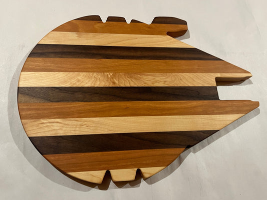 Wooden cutting board shaped like a spaceship on a light gray background
