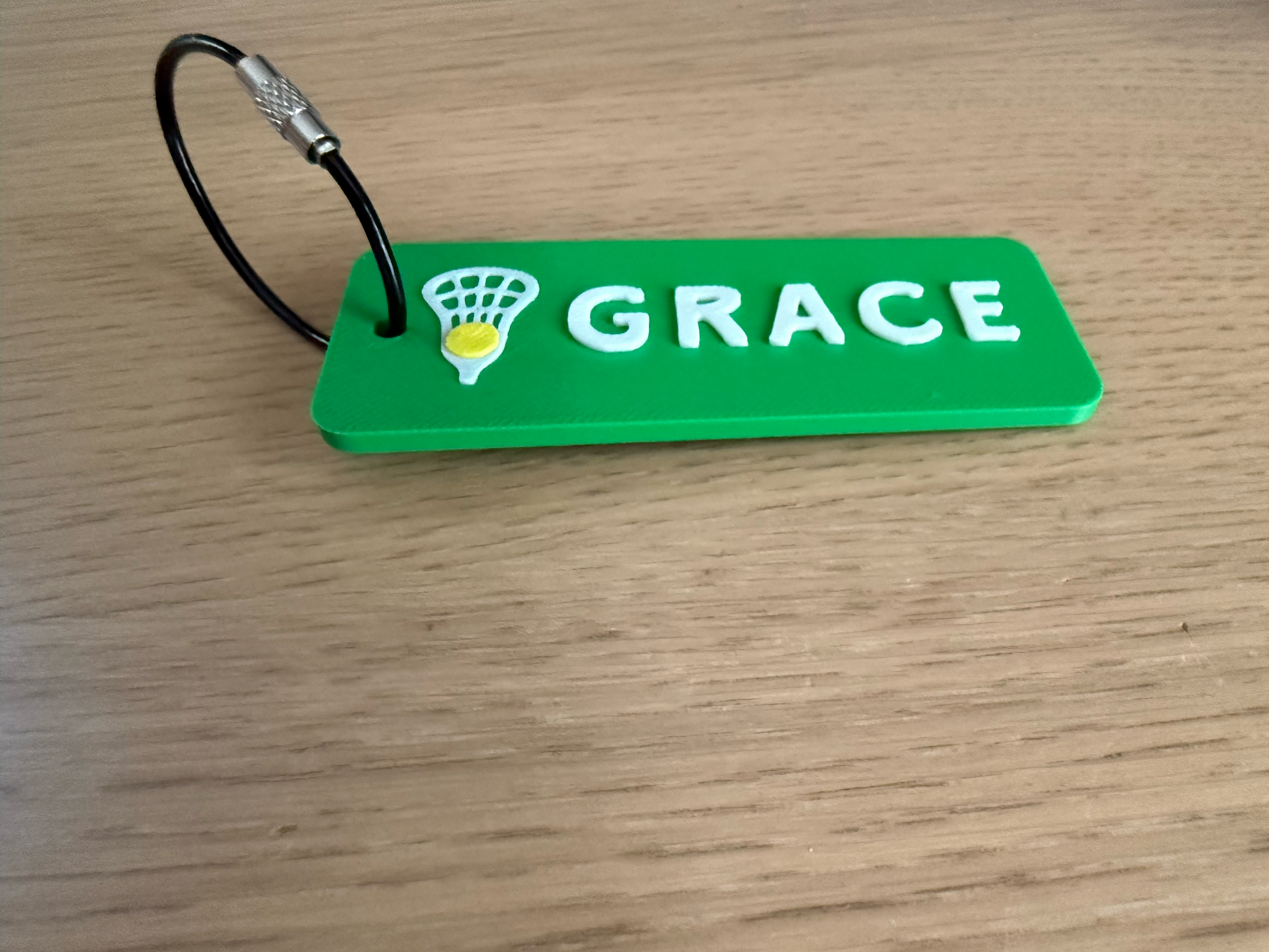 Batch of personalized green lacrosse bag tags printing on a 3D printer