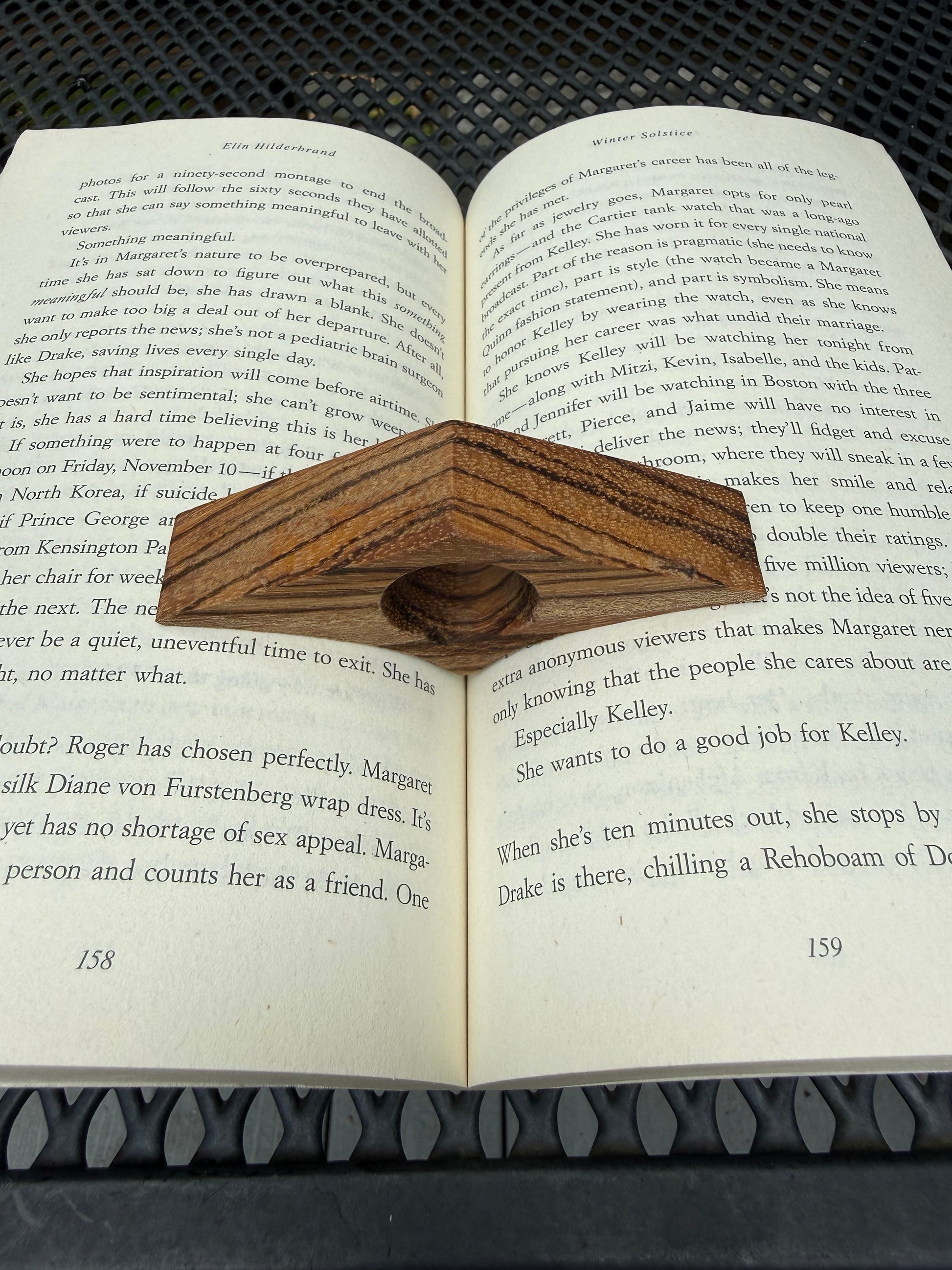 Wooden thumb page holder slipped over thumb while reading a book