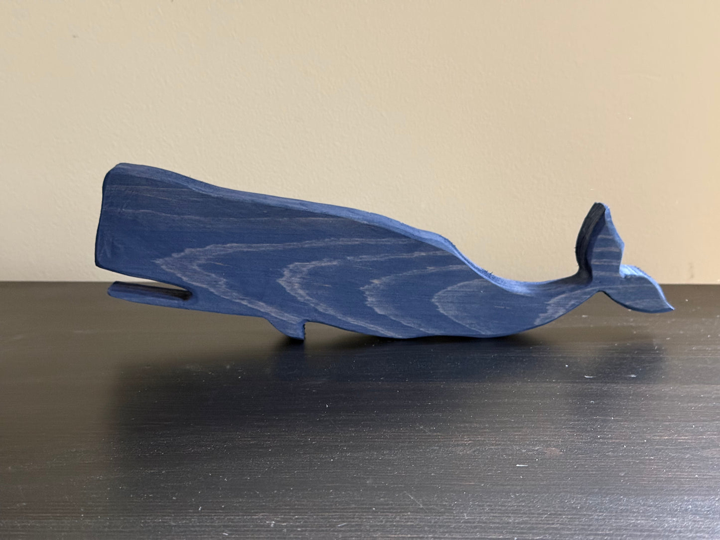 Blue wooden whale-shaped object on a plain background