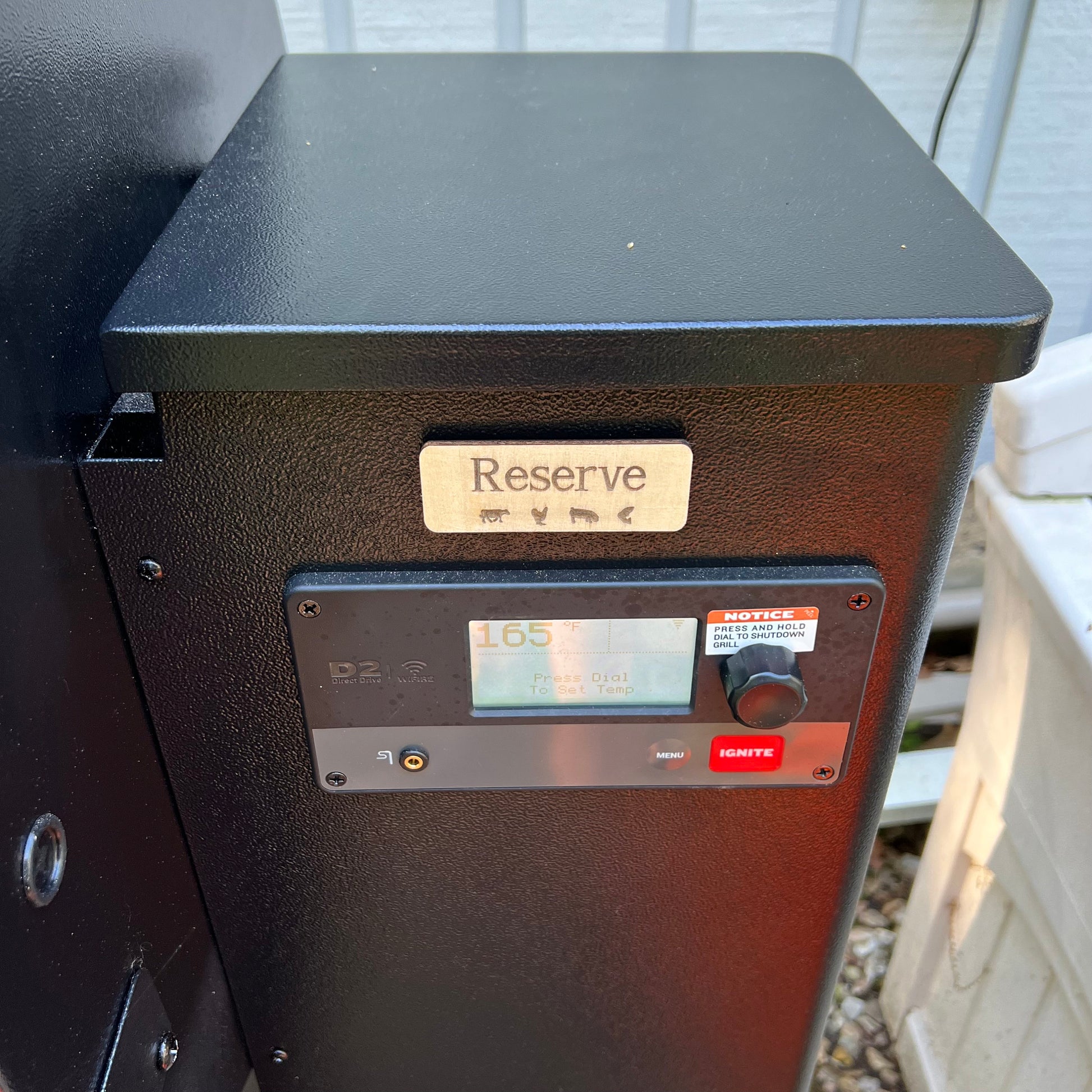 A collage displays Wet Nose Woodworks Laser Cut File: Smoker Grill Wood Pellet Label Magnets—Mesquite and Reserve—plus black-and-white SVG design templates, a Reserve label on a grill, and Lightburn/xTool file icons.
