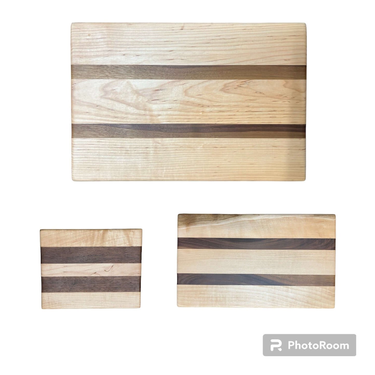 Three Wet Nose Woodworks Walnut and Maple Racing Stripe Cutting Boards are arranged on a white background, featuring alternating light and dark wood stripes. The largest board is on top, with two smaller boards below.